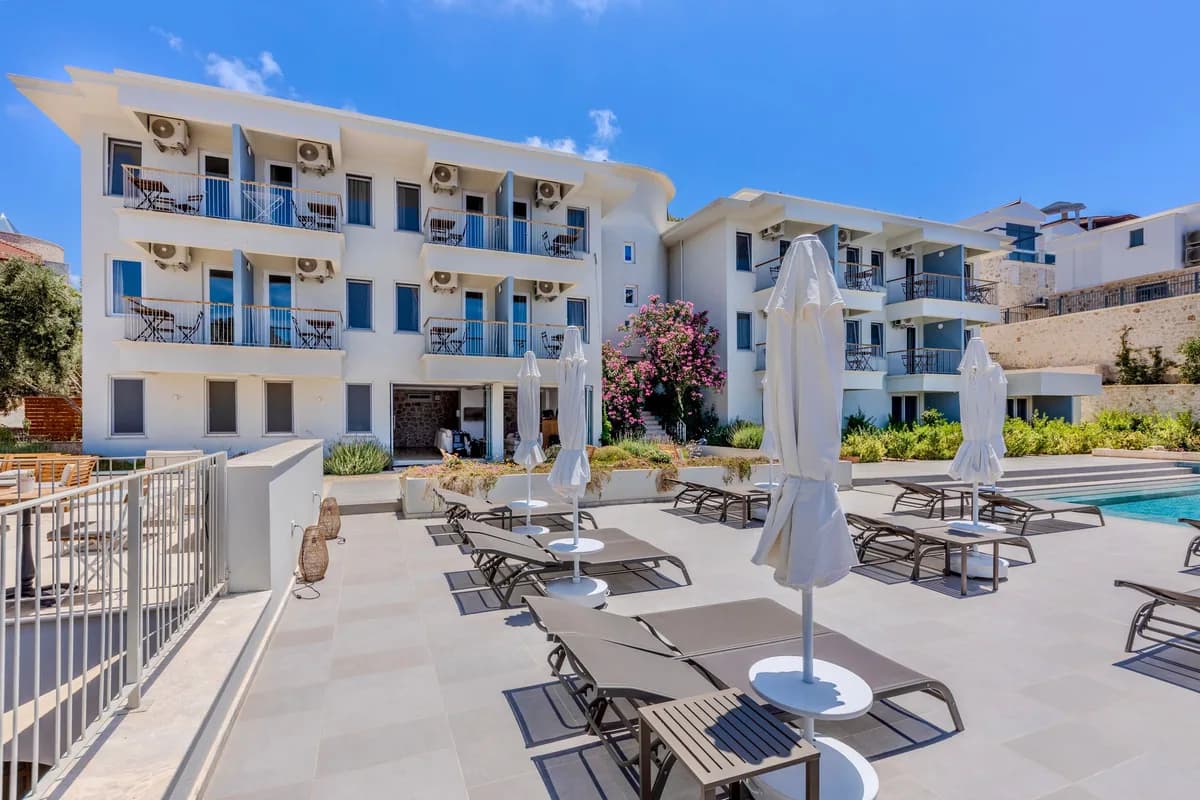 Fachada y piscina de un hotel con tumbonas al sol